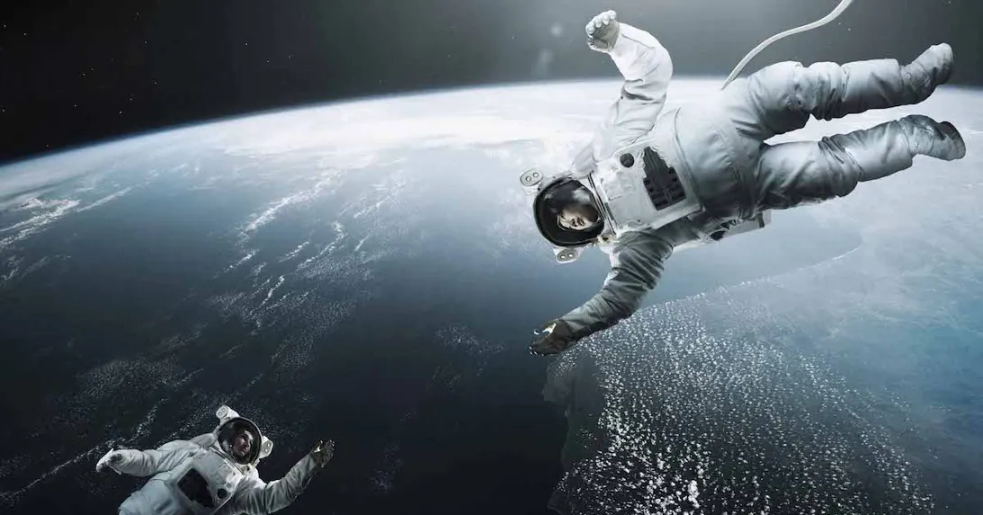 Two astronauts floating above earth in space reaching for each other