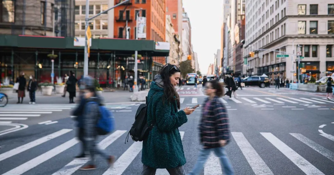 People walking across a crosswalk in the streets of a large city People walking across a crosswalk in the streets of a large city
