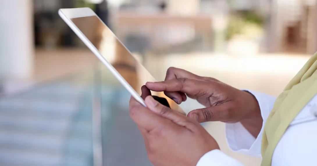 Someone holding a tablet near their torso Someone holding a tablet near their torso