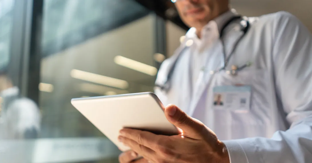A doctor holding a digital tablet reviewing a patient's record A doctor holding a digital tablet reviewing a patient's record