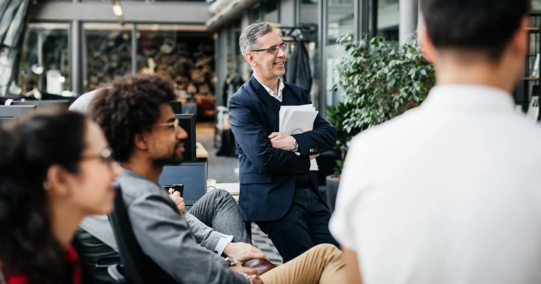 Several people sitting in a garden area near a building looking at something out of the picture Several people sitting in a garden area near a building looking at something out of the picture