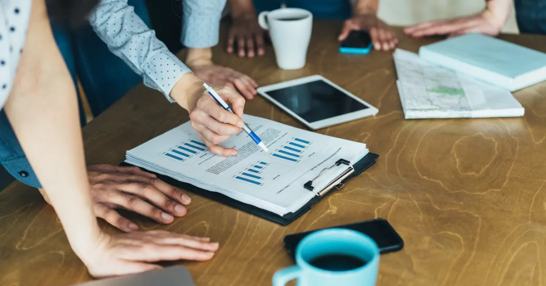 People standing around a table looking at a piece of paper