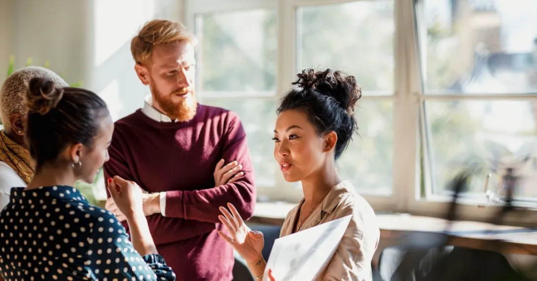 Person in maroon sweater talks with people wearing beige, polka dots Person in maroon sweater talks with people wearing beige, polka dots