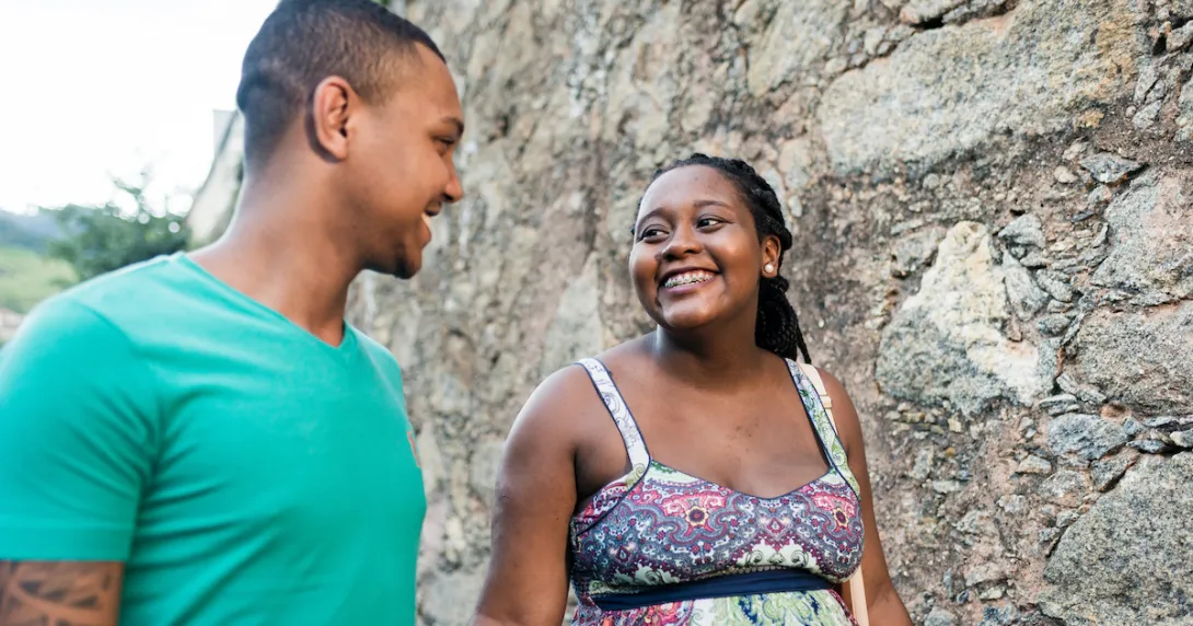 Two people walking together while looking at each other and smiling Two people walking together while looking at each other and smiling