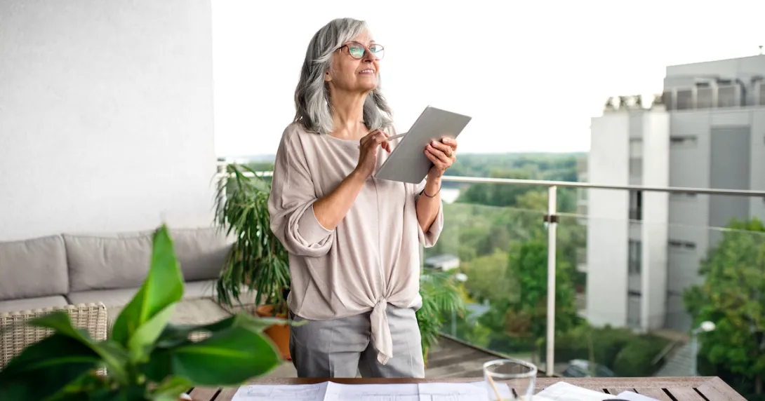 Person holding a tablet while standing on a balcony Person holding a tablet while standing on a balcony