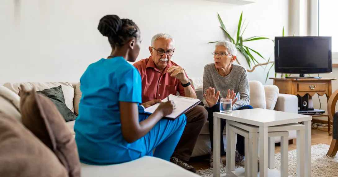 Two people sitting on a couch talking to a healthcare provider who is sitting on a different couch Two people sitting on a couch talking to a healthcare provider who is sitting on a different couch