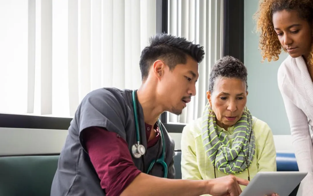 Healthcare professional discusses with two people over a laptop Healthcare professional discusses with two people over a laptop