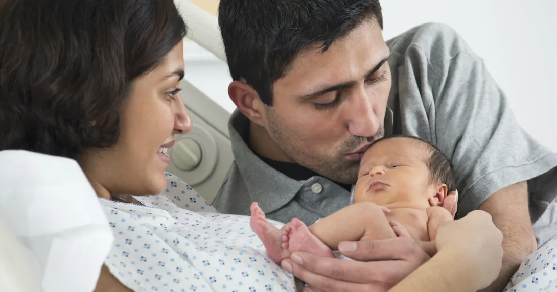 A newborn child with their parents