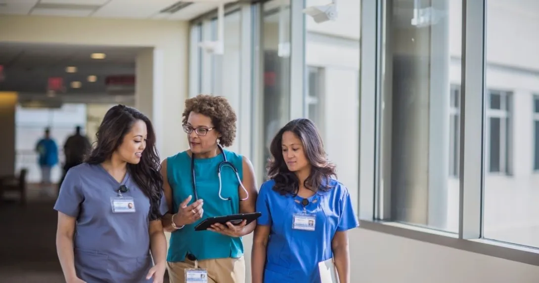 three people walking together three people walking together in a hospital