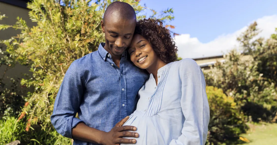 A man posing with a pregnant woman A man posing with a pregnant woman