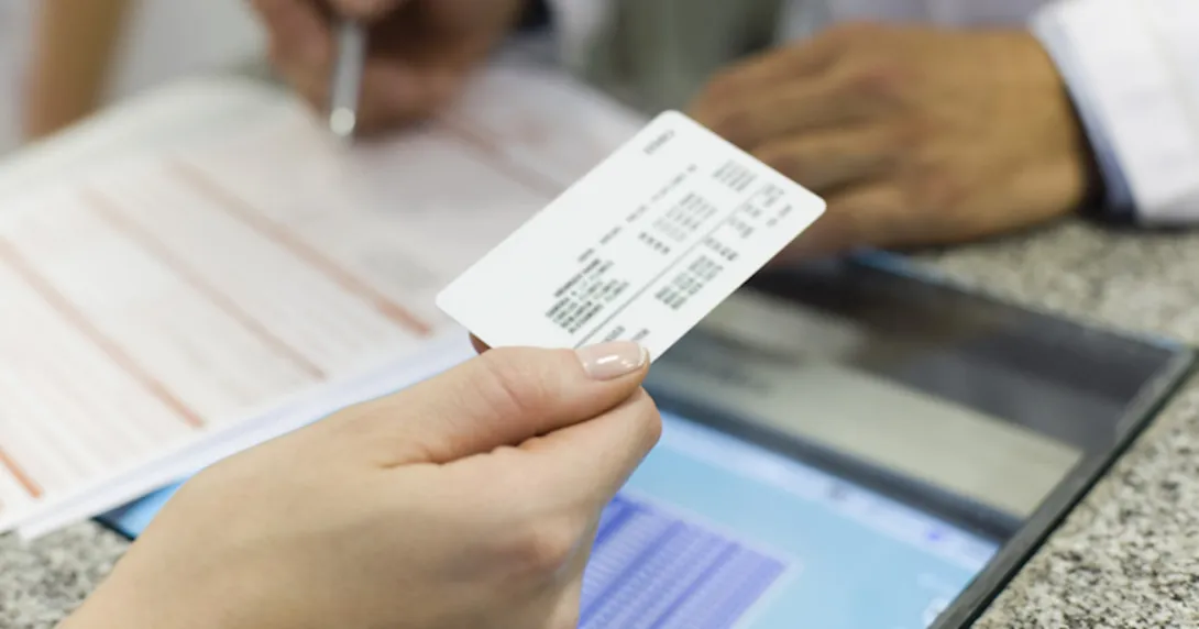 Insurance card being passed across a counter