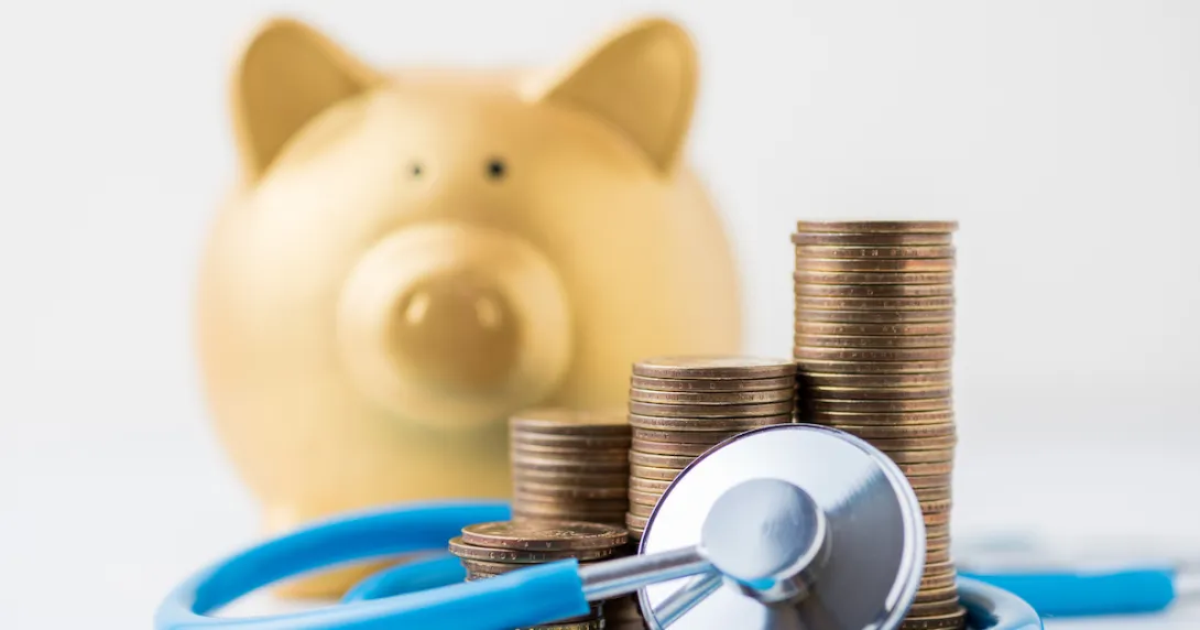 A piggy bank with a stethoscope and a pile of coins. A piggy bank with a stethoscope and a pile of coins.