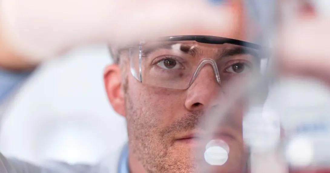 Clinician examining the contents of a test tube Clinician examining the contents of a test tube