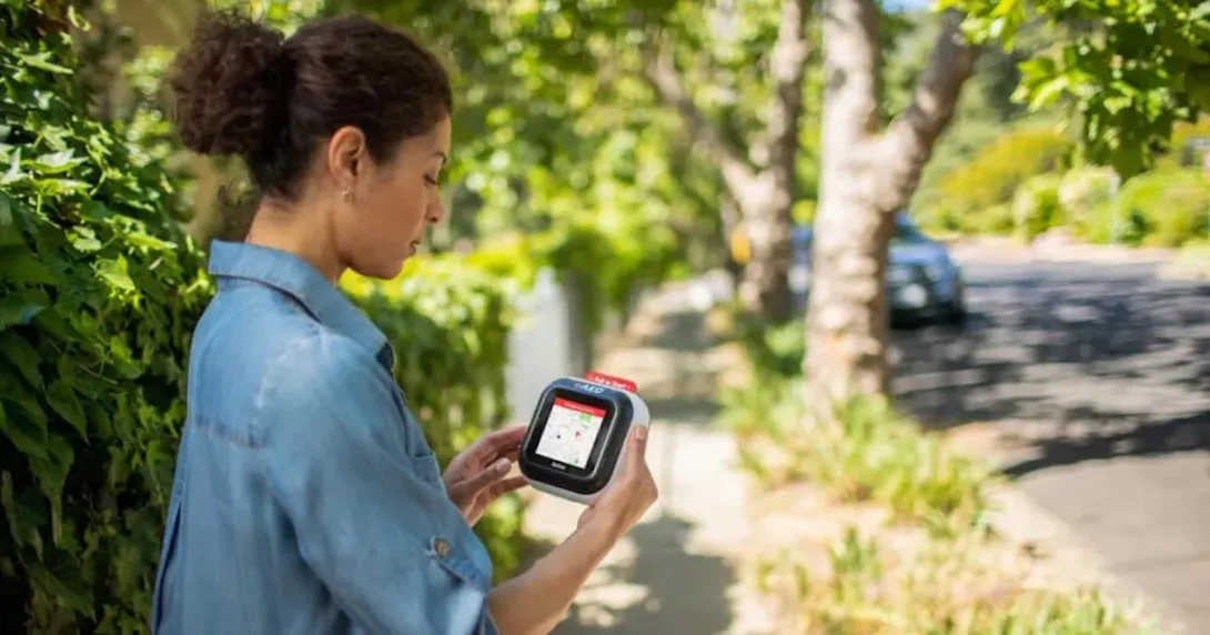 A woman holding the Avive device that is displaying a map A woman holding the Avive device that is displaying a map
