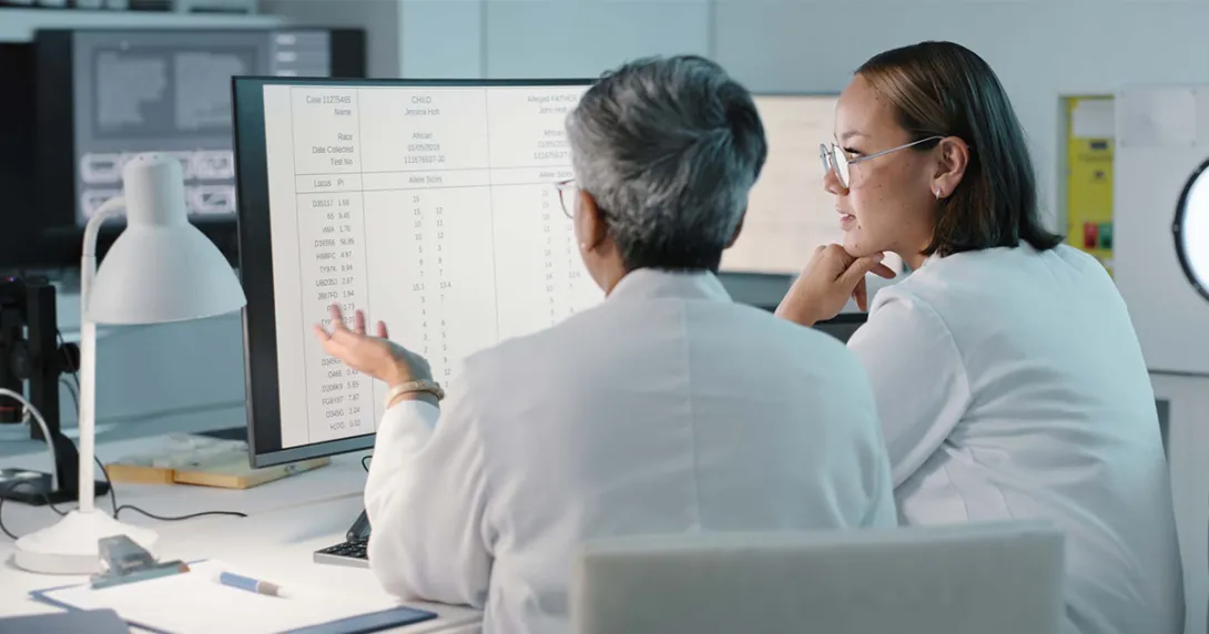 Healthcare workers looking at a spreadsheet on a computer monitor Healthcare workers looking at a spreadsheet on a computer monitor