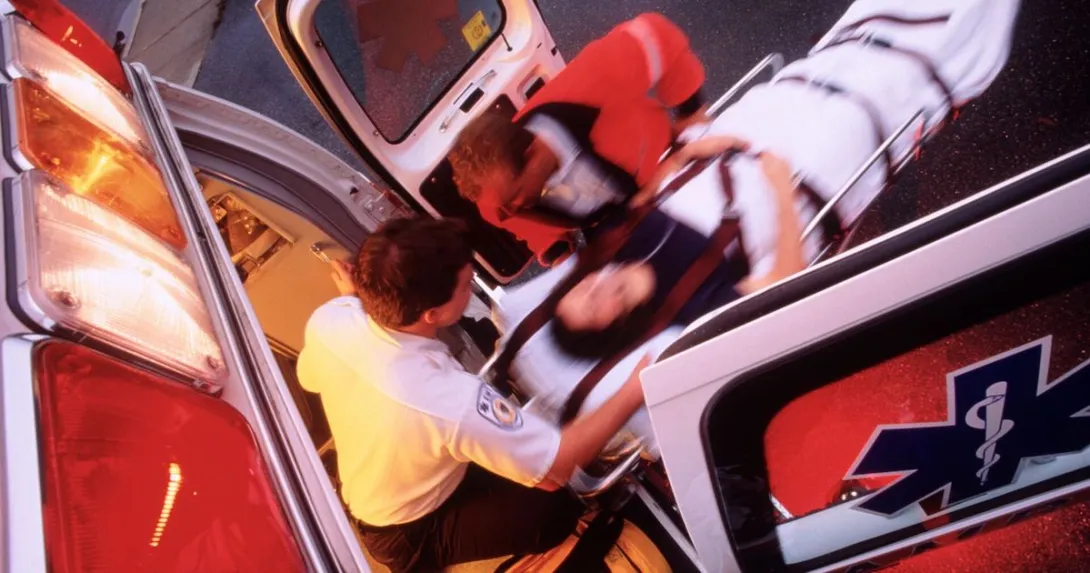 Paramedics loading a patient onto an ambulance Paramedics loading a patient onto an ambulance