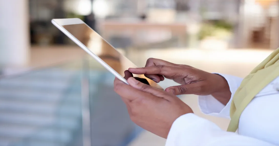 A close up photo of a woman using a tablet.