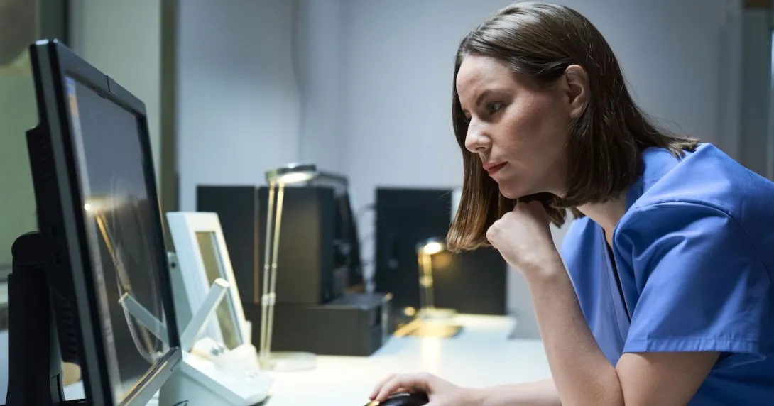 A doctor looking at a MRI results on a desktop computer A doctor looking at a MRI results on a desktop computer