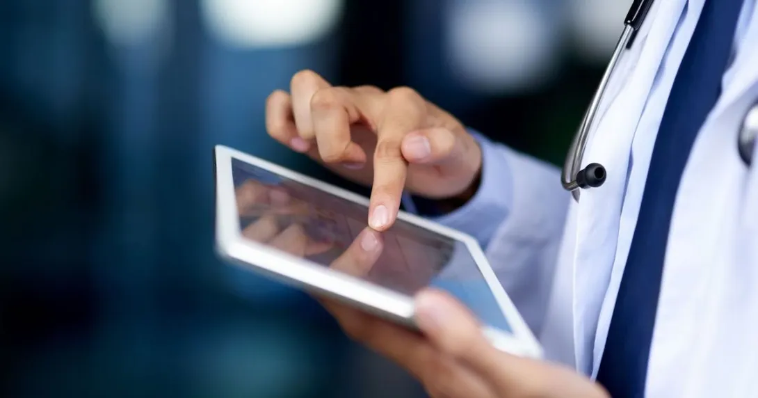 A close-up of a doctor using a tablet. A close-up of a doctor using a tablet.