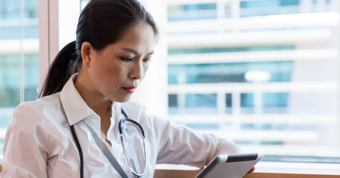 A clinician using a tablet. A clinician using a tablet.
