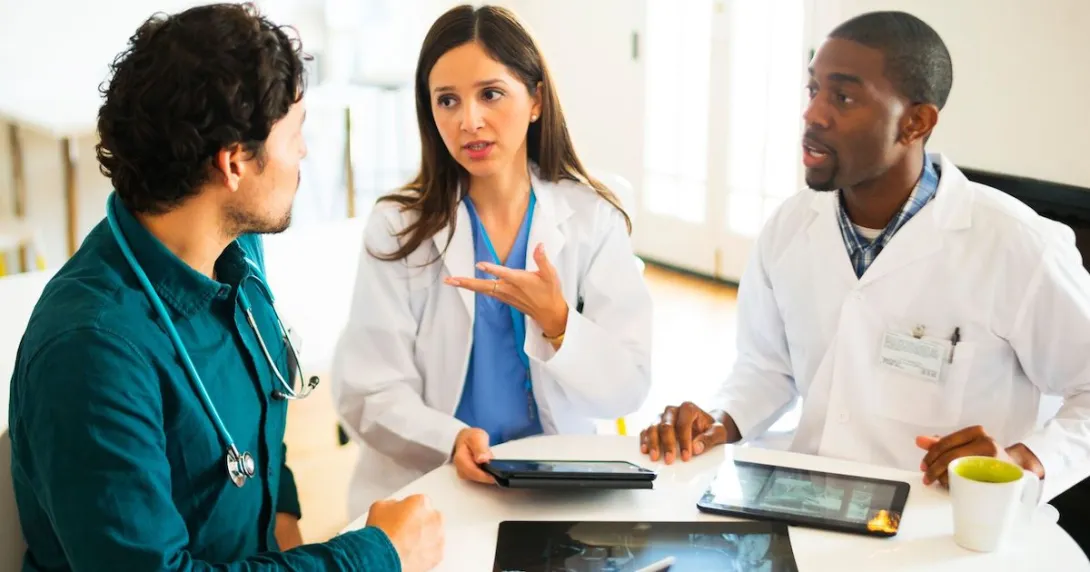 Doctors talking together with digital tablets and X-rays. Doctors talking together with digital tablets and X-rays.