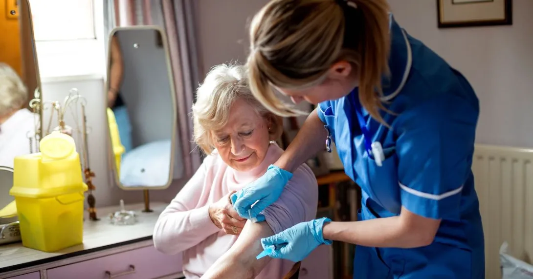 A nurse helping an older woman in her home A nurse helping an older woman in her home