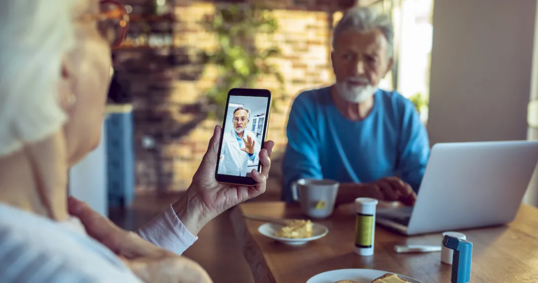 An older couple talking to a doctor via telehealth An older couple talking to a doctor via telehealth