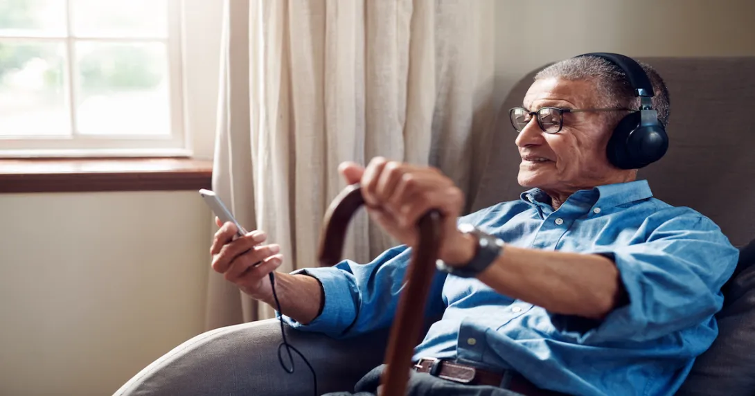 An older man using a smartphone at home. An older man using a smartphone at home.