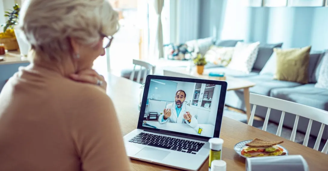 A person talking to a doctor via video call on her laptop. A person talking to a doctor via video call on her laptop.