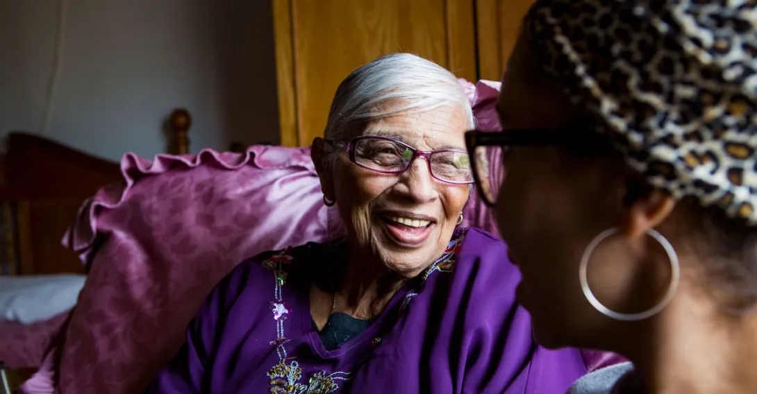 An older woman sitting with a younger woman at home. An older woman sitting with a younger woman at home.