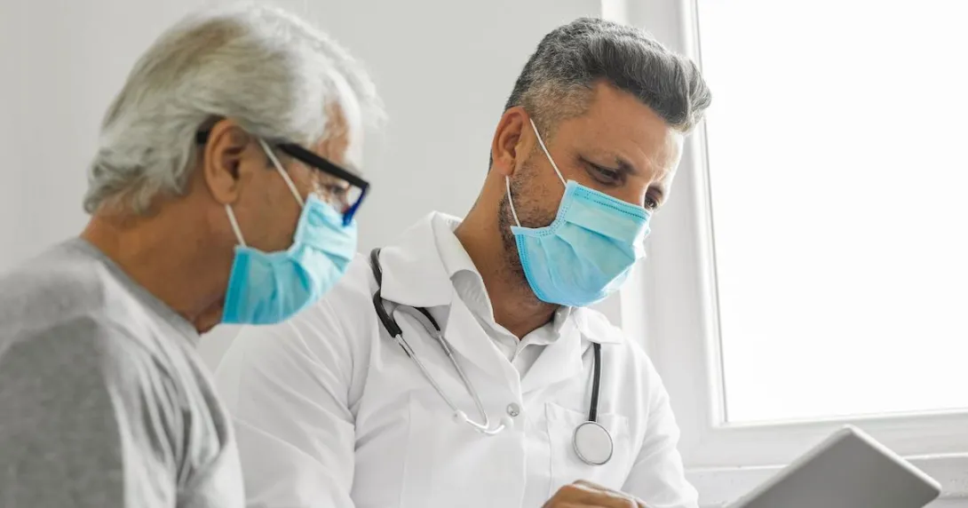 An older man and doctor looking at results on a tablet. An older man and doctor looking at results on a tablet.