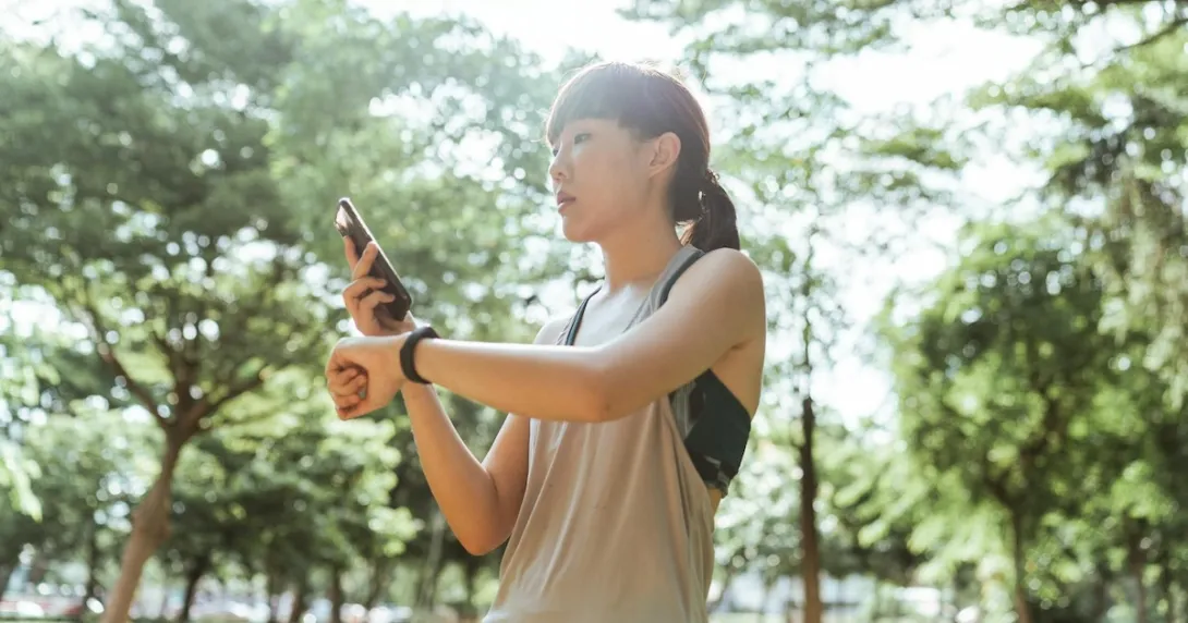 A person checking their fitness tracker data on their mobile phone A person checking their fitness tracker data on their mobile phone
