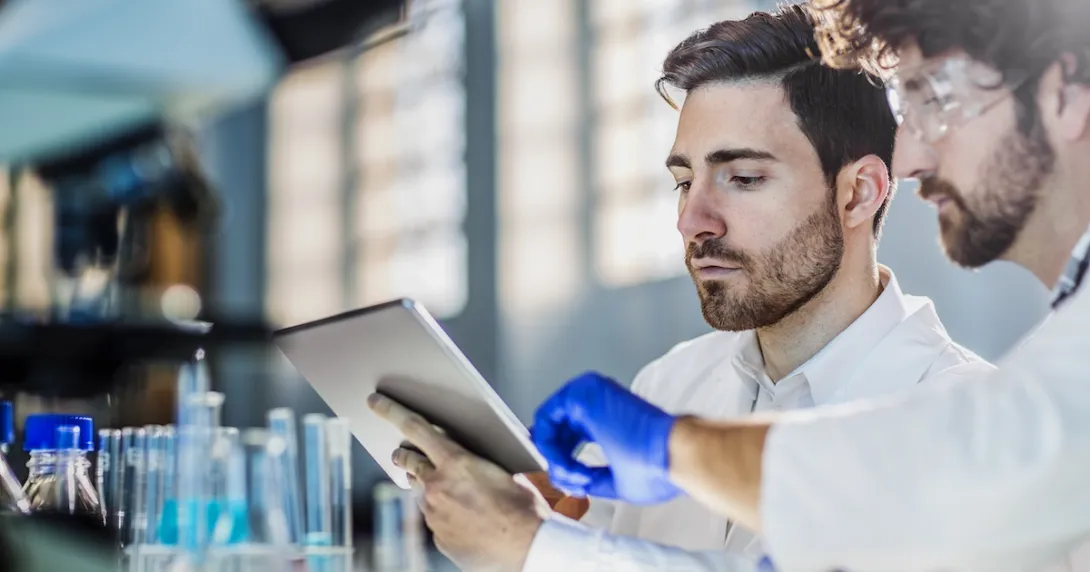 Two scientists in a lab looking at a tablet Two scientists in a lab looking at a tablet