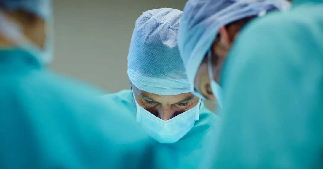 A close up of surgeons working in an operating room. A close up of surgeons working in an operating room.