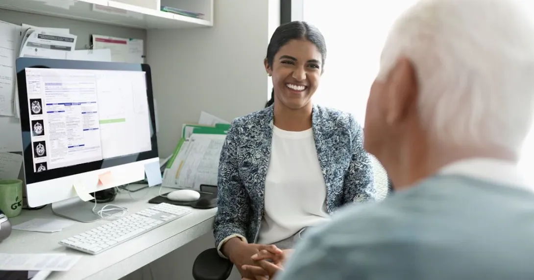 A mental healthcare provider talking to an older patient in the foreground A mental healthcare provider talking to an older patient in the foreground