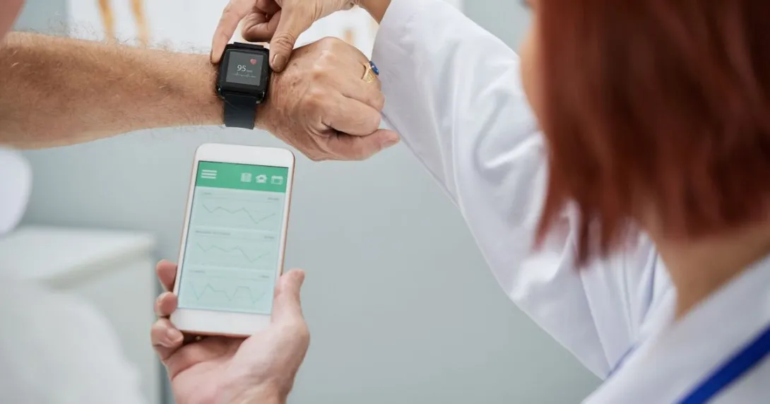 Doctor showing patient how to synchronize health app in smartphone and smartwatch Doctor showing patient how to synchronize health app in smartphone and smartwatch