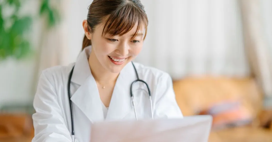 Healthcare provider sitting at a desk looking at a computer Healthcare provider sitting at a desk looking at a computer