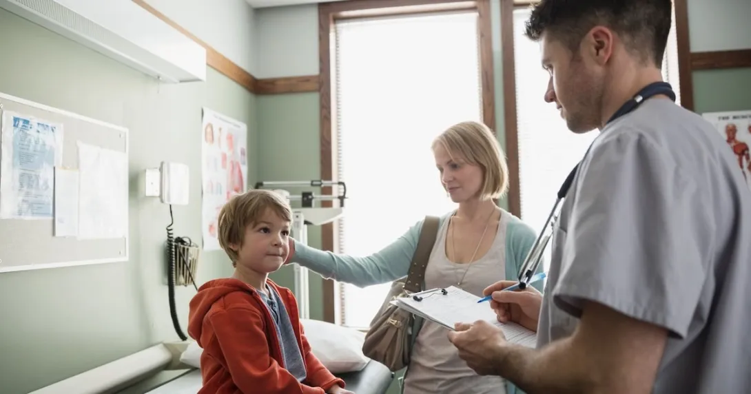 Healthcare provider with a patient and their caregiver in a clinic Healthcare provider with a patient and their caregiver in a clinic