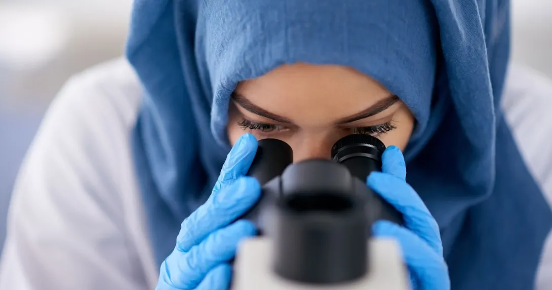 Healthcare provider looking through a microscope