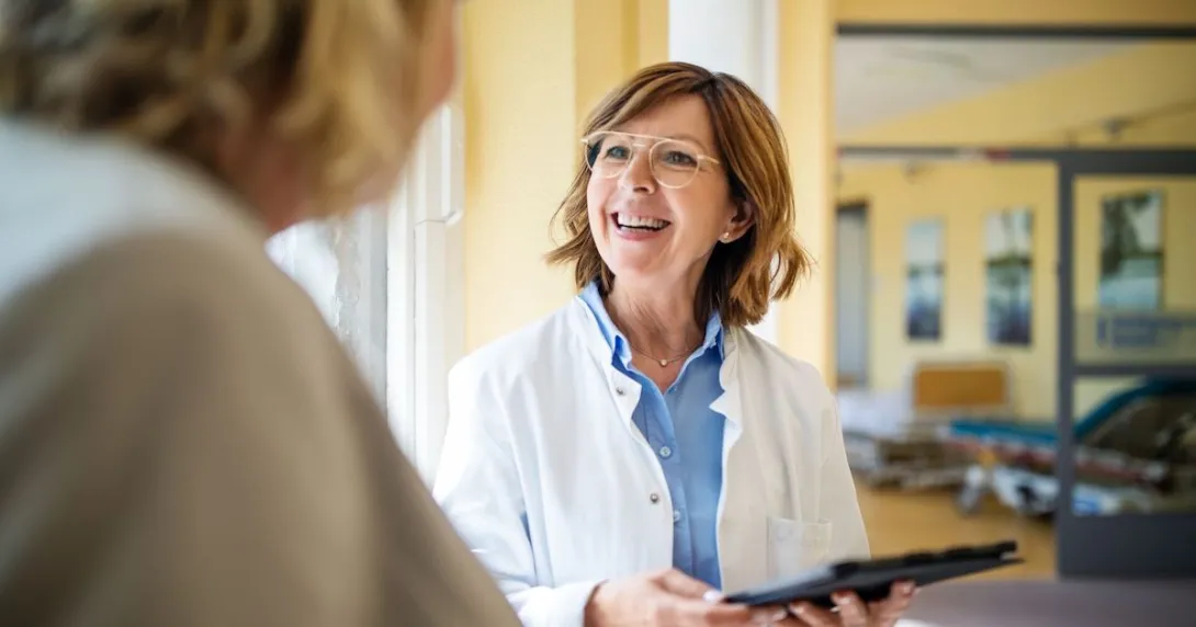 Healthcare provider speaking to a patient while smiling Healthcare provider speaking to a patient while smiling
