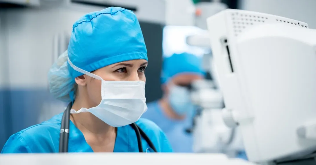 Surgeon in an operating room looking at a computer screen Surgeon in an operating room looking at a computer screen