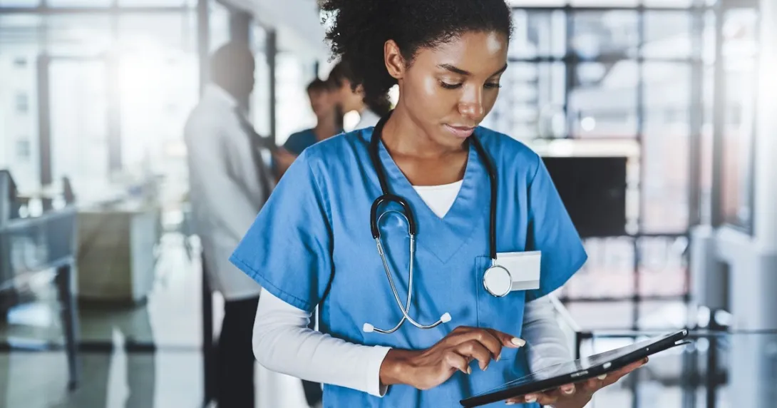 Healthcare professional in scrubs looking at a tablet Healthcare professional in scrubs looking at a tablet
