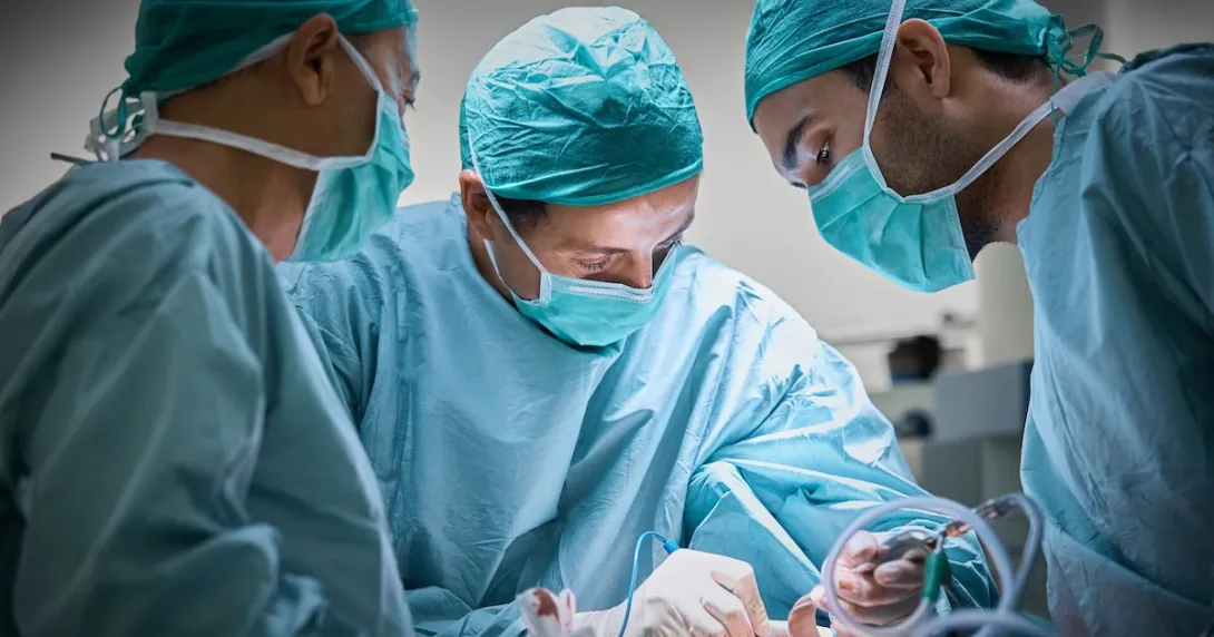 Three surgeons operating on a patient Three surgeons operating on a patient
