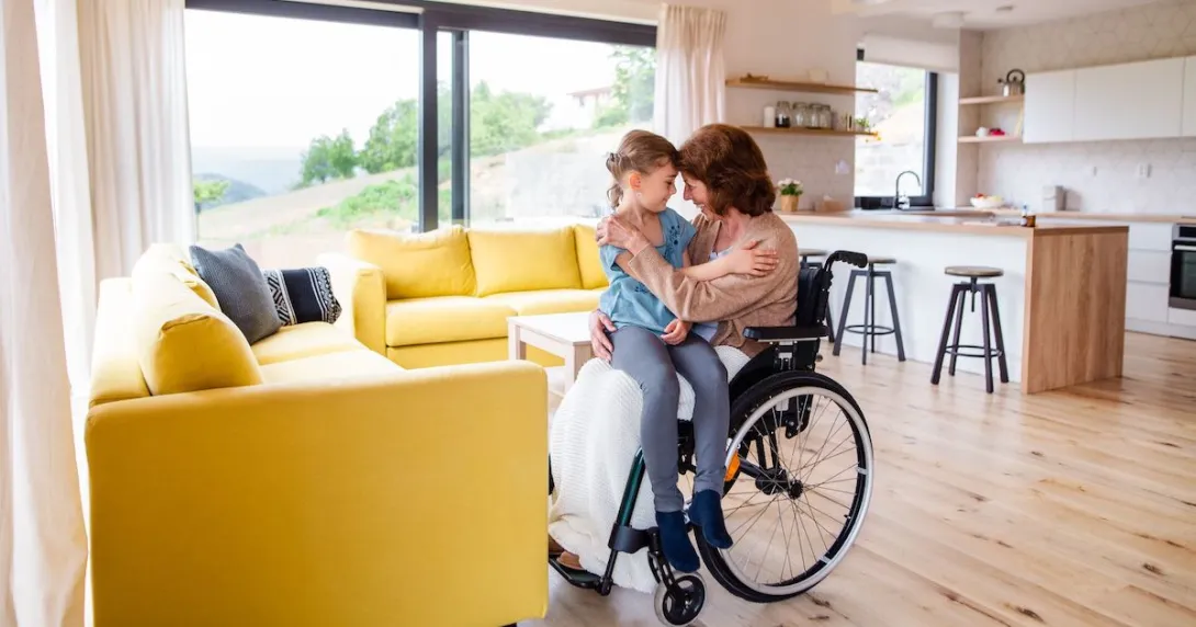 A person in a wheelchair holding a child A person in a wheelchair holding a child
